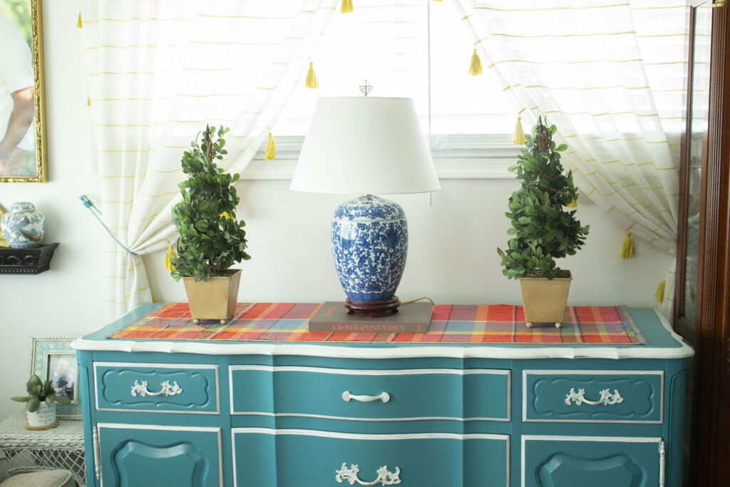 Turquoise blue buffet table  styled with topiaries and a blue and white porcelain lamp