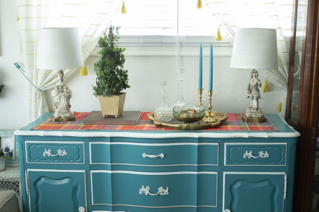 Turquoise blue buffet table styled with a topiary and French figurine lamps