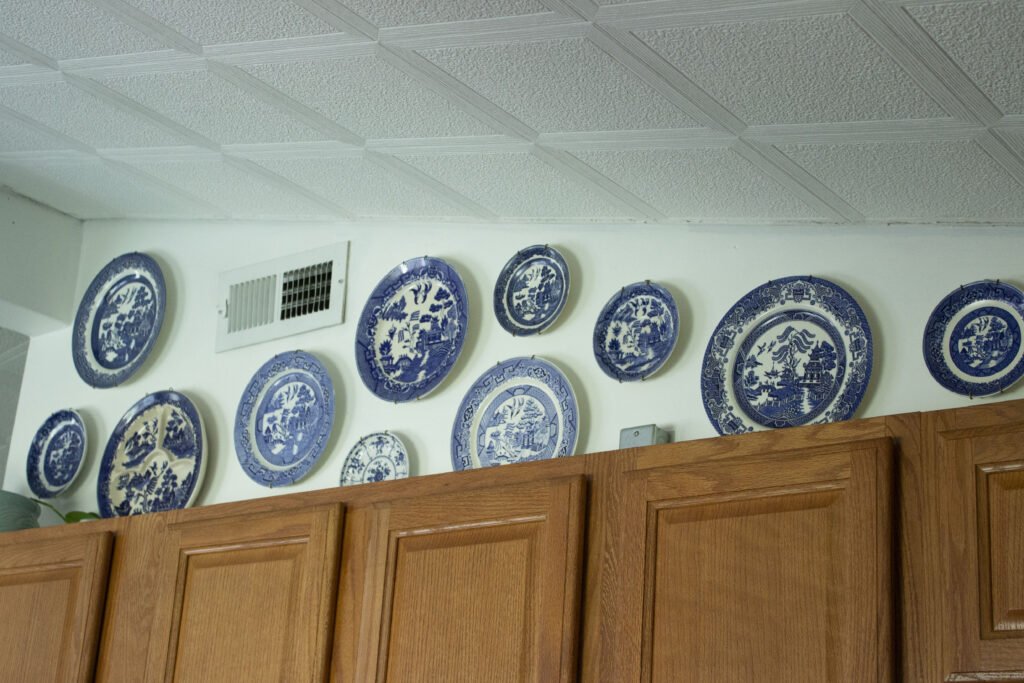 How to Create a Plate Wall: Collection of Blue Willow Plates above Kitchen cabinets