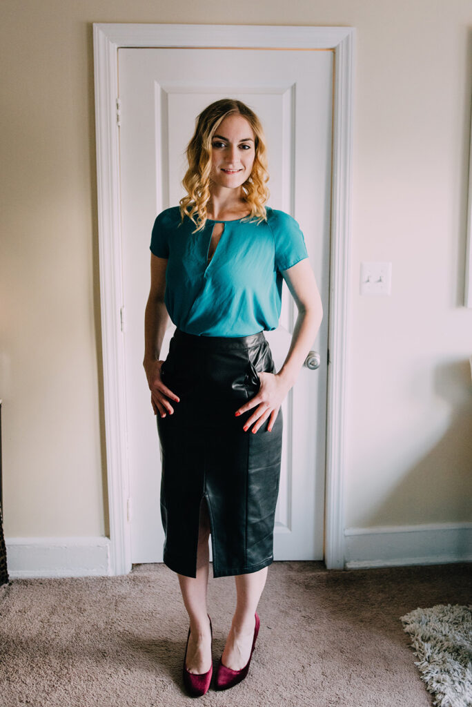 Woman in leather pencil skirt and turquoise top with red shoes