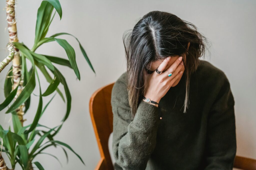 Woman with head in hand, how to cope with anxiety