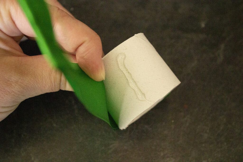 Hot gluing a ribbon to a paper towel tube