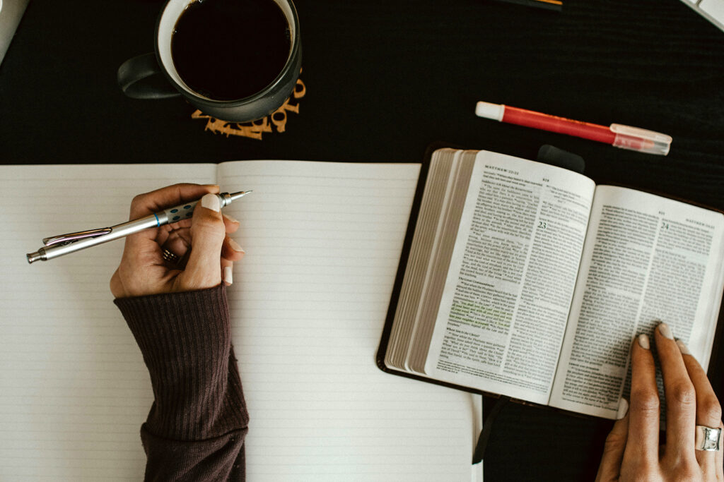 making time for God as a mom: Woman reading bible and writing in journal