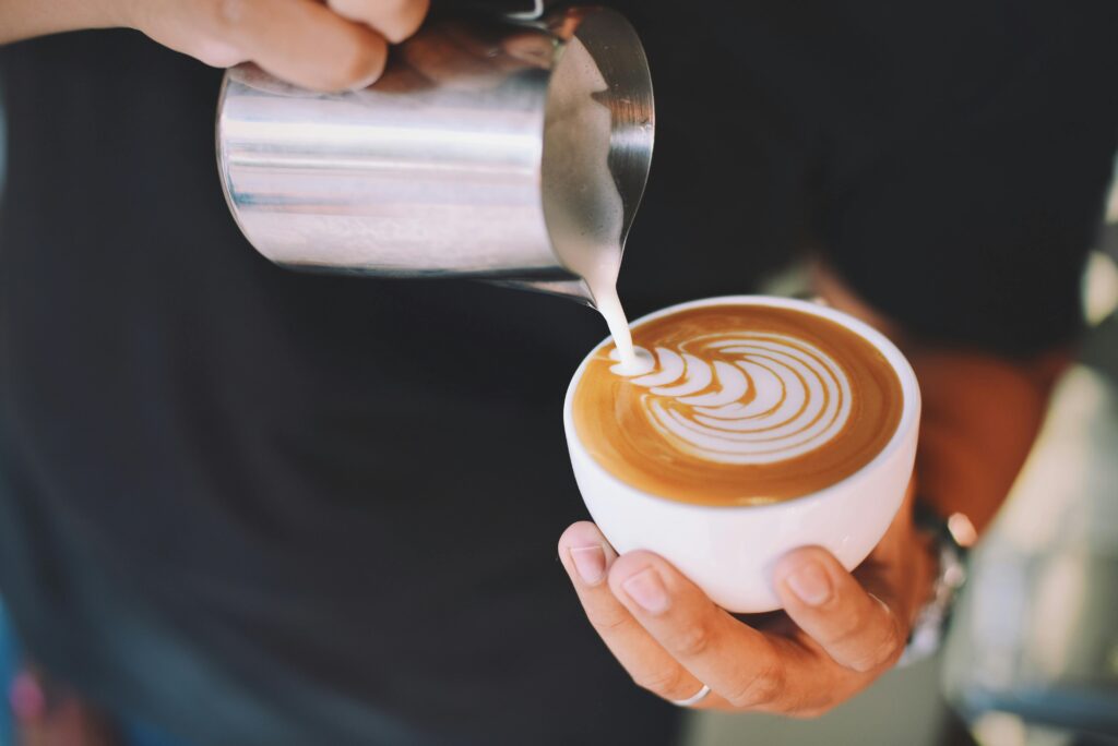 Barista Pouring Milk into a latte