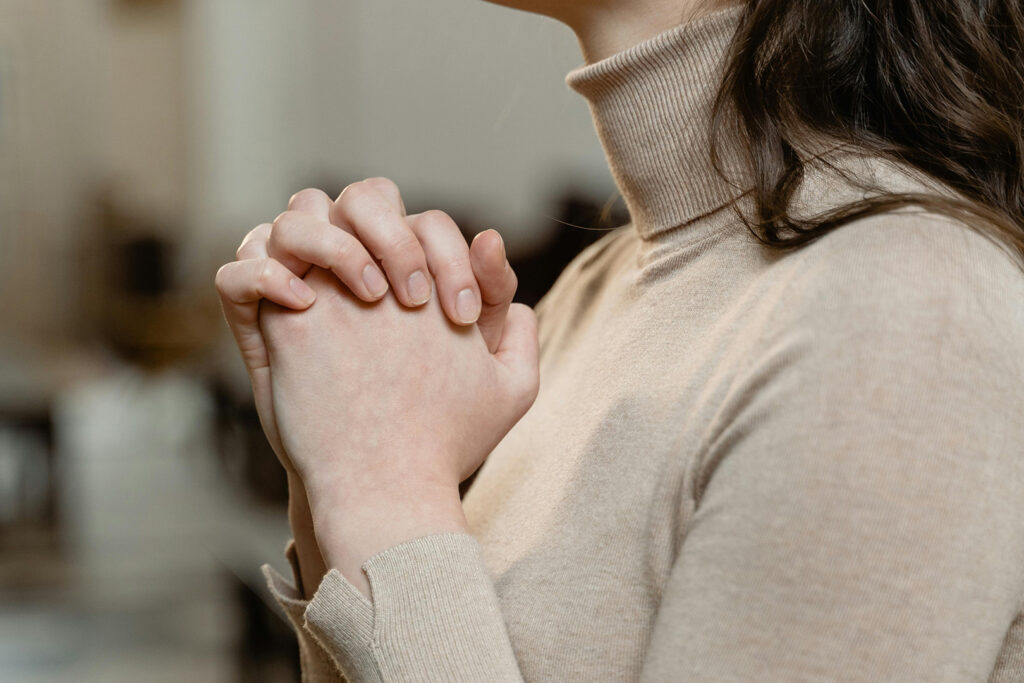 Faith: Woman with hands clasped in prayer