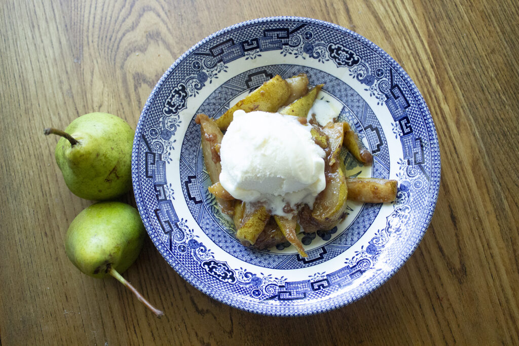 Stovetop Pear Cobbler in a Blue Willow bowl with two pears