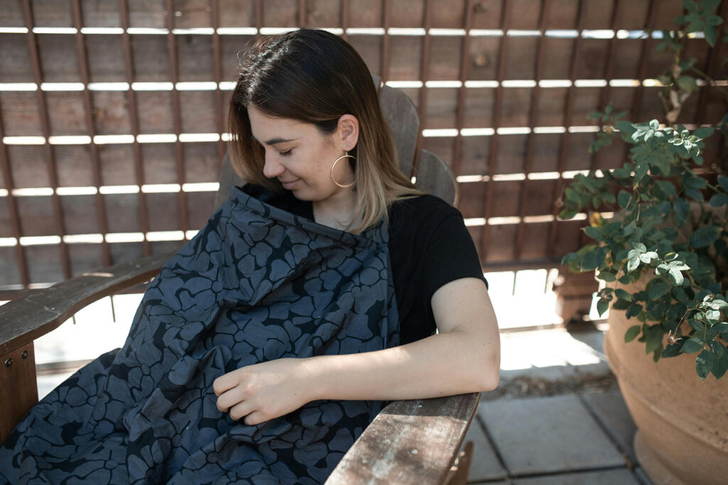 My breastfeeding journey: woman breastfeeding with a nursing cover