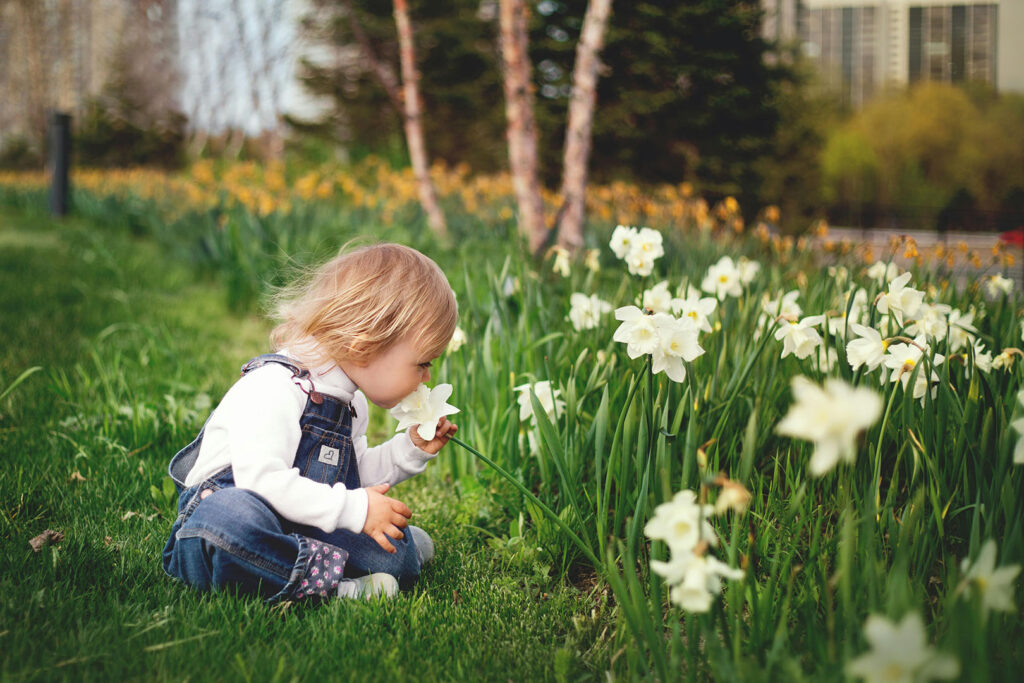 Spiritual Protection for Your Children: Little girl smelling flowers in a garden